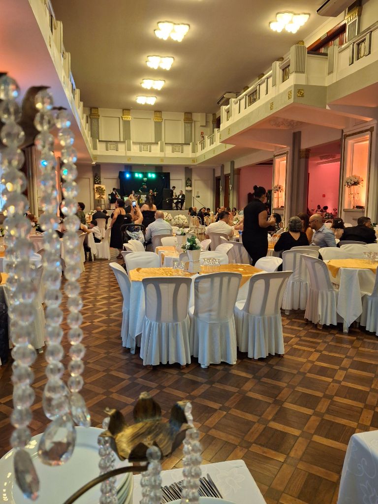 Salão de festas decorado com mesas e balcão