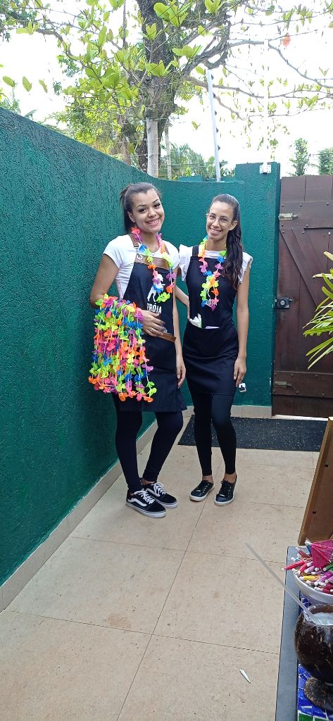 Bartenders com uniforme e colares havaianos